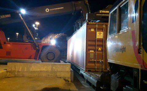 Loading containers at Southampton Docks Nighttime view of reachstacker placing container on train