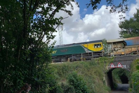 Freightliner aggregates train passes a wooded section of line near Dronfield