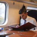 UK Prime Minister Rishi Sunak working on government folder on board a train in a first class carriage