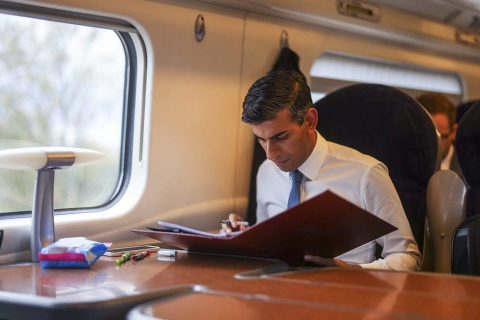 UK Prime Minister Rishi Sunak working on government folder on board a train in a first class carriage