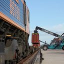 iPortRail reach stacker loading an intermodal train as seen from the cab side of the locomotive