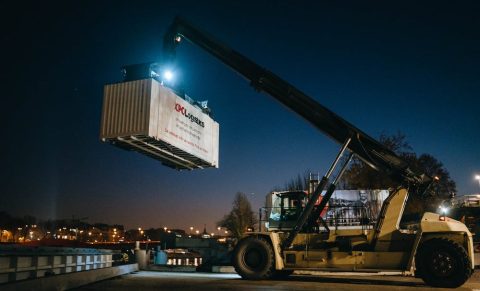 Night time shot of reach stakes moving XPO liveried container